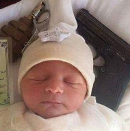 Безумието няма граници! Снимаха бебе с граната и пистолет с надпис: "Това дете няма да бъде ...