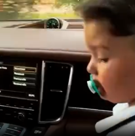 Дете на предната седалка на луксозен автомобил