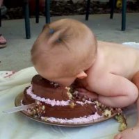 Първият рожден ден-бебе яде торта