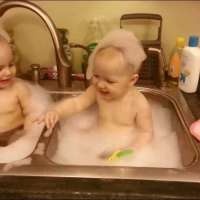 Сладки близнаци се къпят в мивката