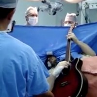 Пациент свири на китара по време на собствената си операция на гравата